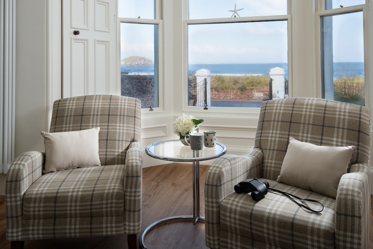 East Bay Beach House - large bay window in the sitting room with armchairs