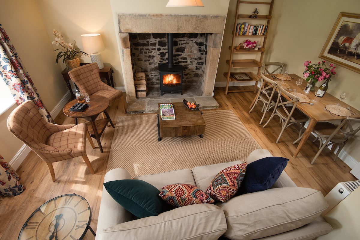 Aydon Castle Cottage - the open-plan living area with inglenook fireplace and wood burning stove