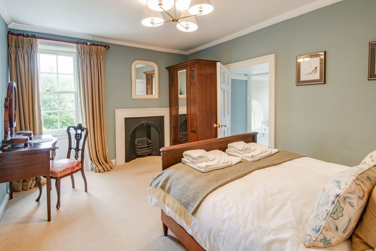 Abbey House - bedroom two with antique double bed, dressing table and fireplace