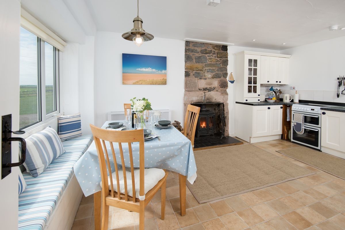 Beachcomber Cottage - the spacious kitchen with dining space and wood burning stove