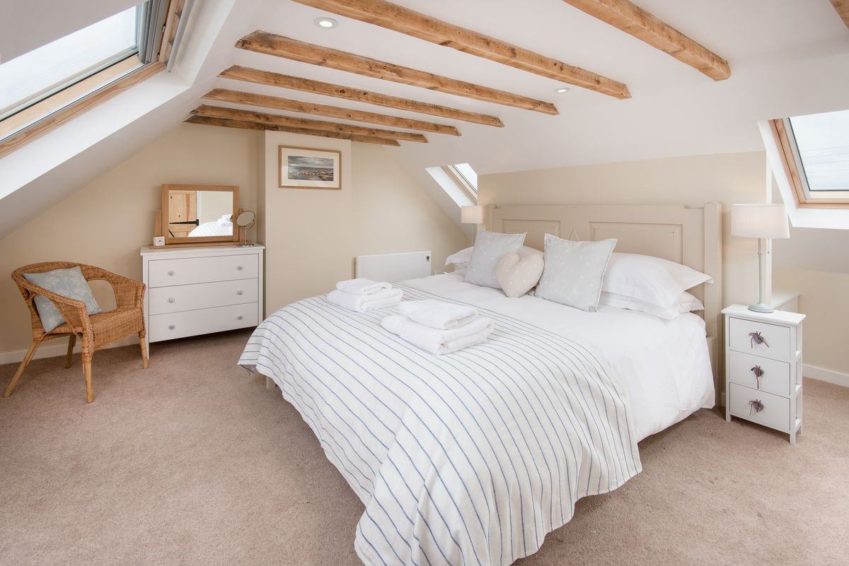 Beachcomber Cottage - bedroom one with super king bed and ceiling beams