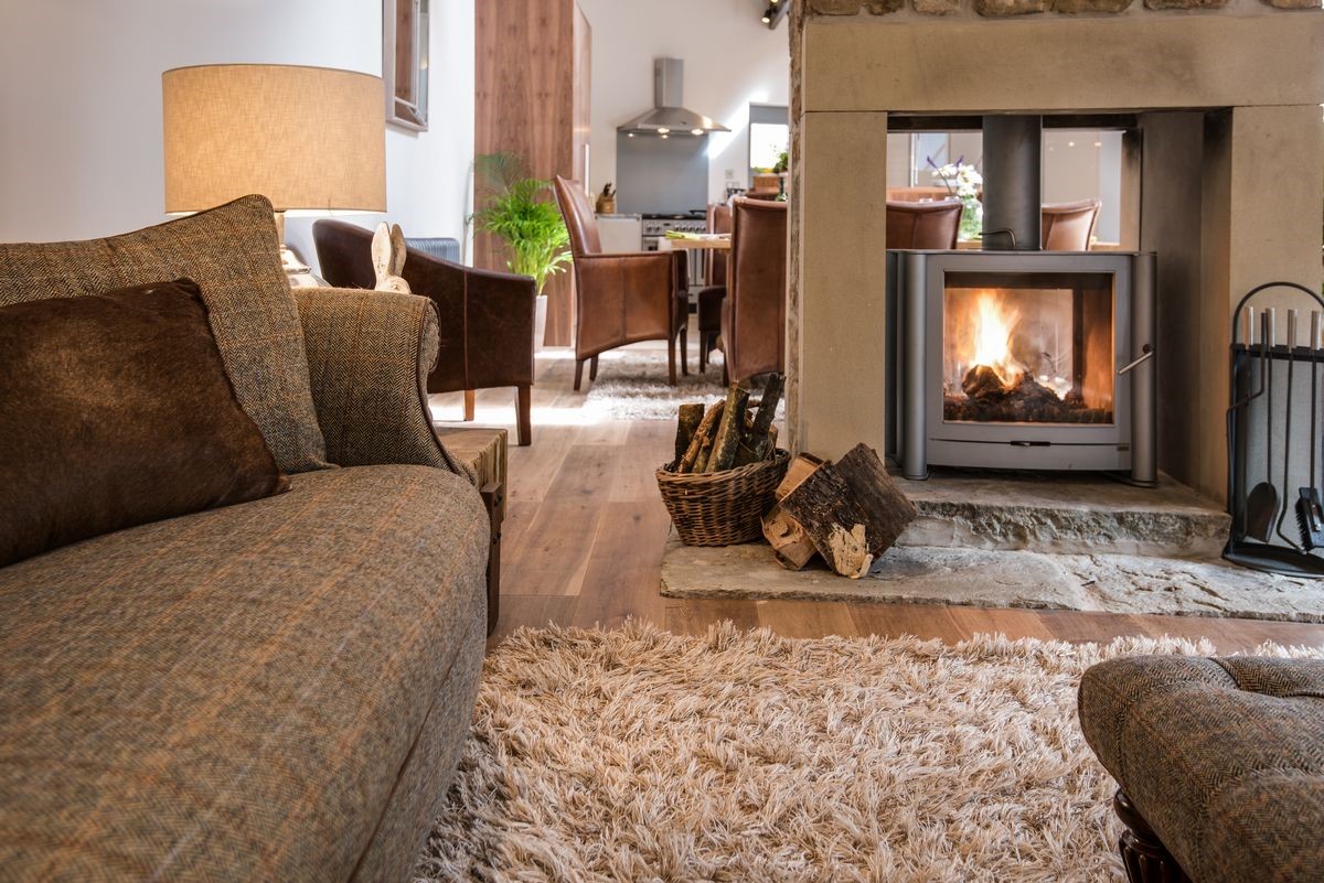 Coach House - the sitting room with wood burning stove leading through into the dining and kitchen area