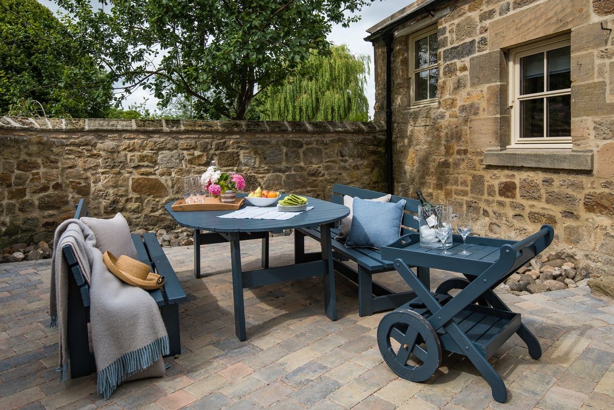 Coach House - outside seating area in the courtyard with bench seating and drinks trolley