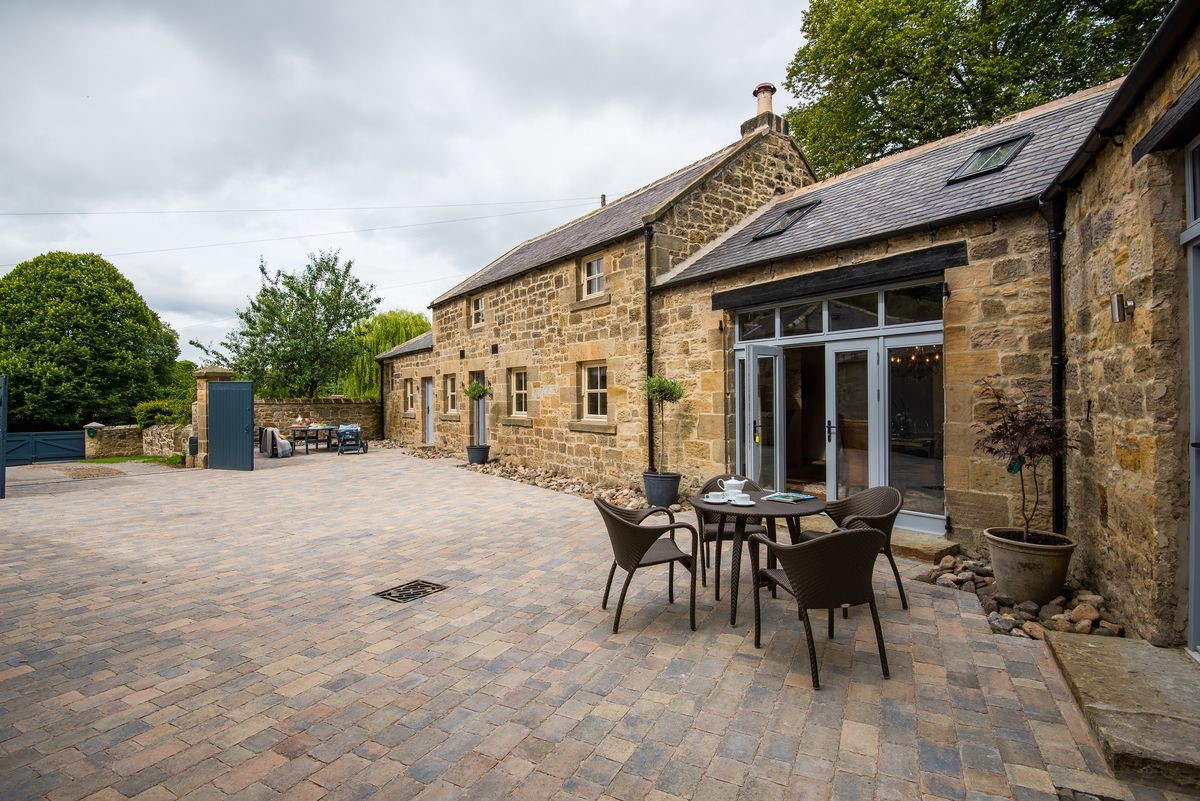 Coach House - courtyard area with outside furniture leading to the shared lawned garden and access gate