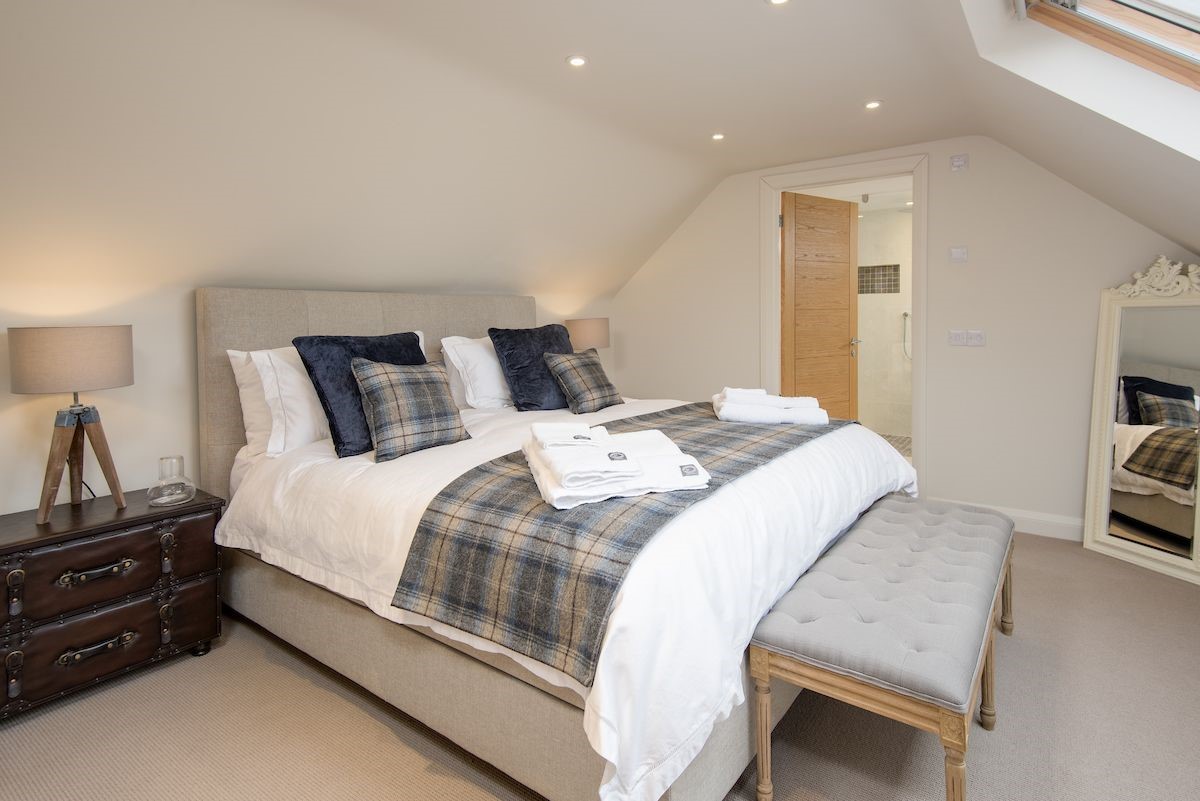 Coledale Stables - bedroom two on the first floor with super king bed, side tables and en suite bathroom