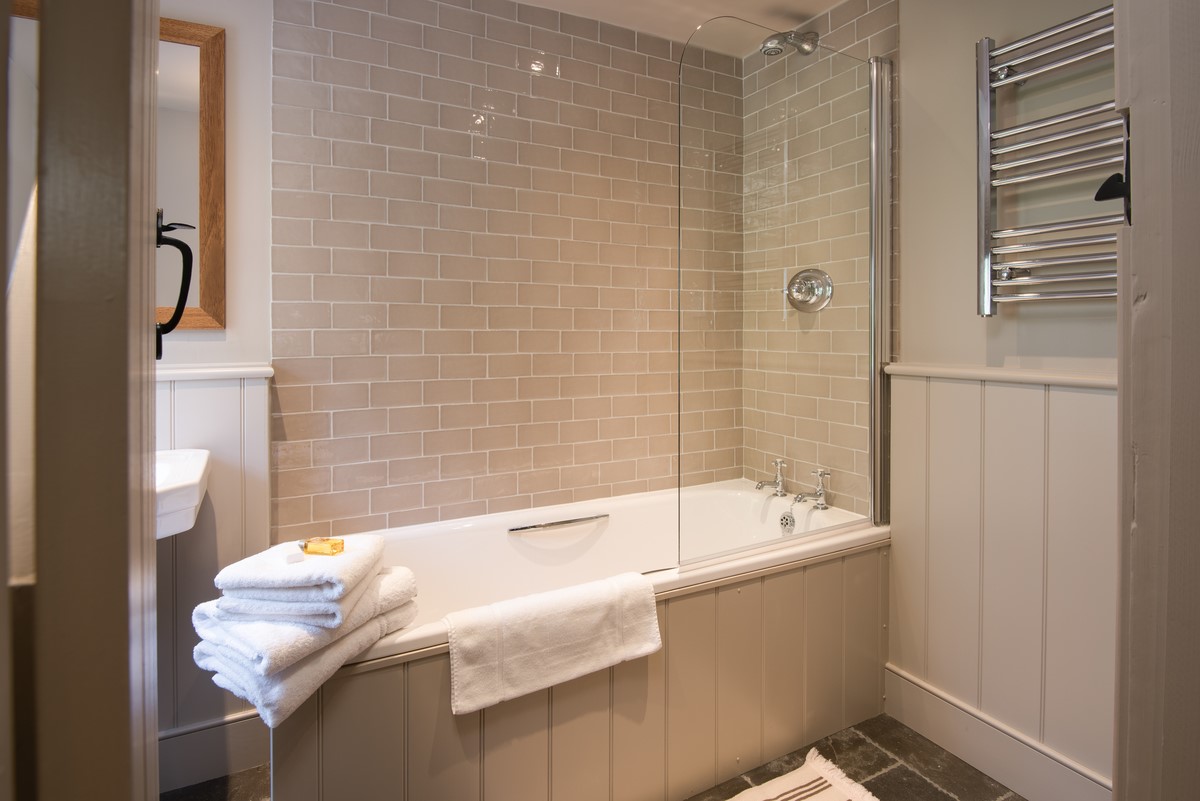 Park End - bath with shower and heated towel rail in the bathroom