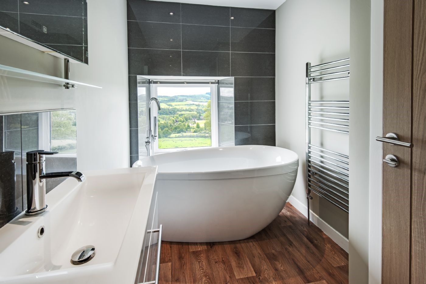 Granary - bedroom one en suite bathroom with feature bath and a view