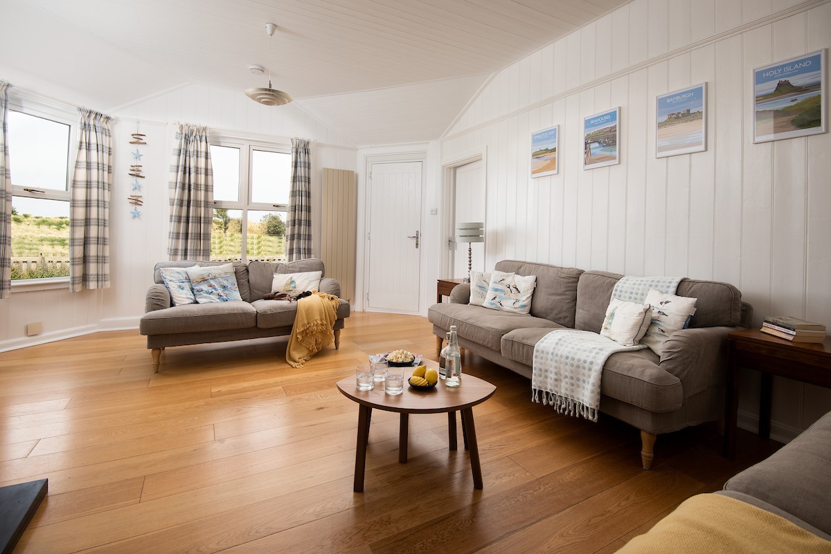 Driftwood Bamburgh - sitting room with plenty of seating and views out to the dunes