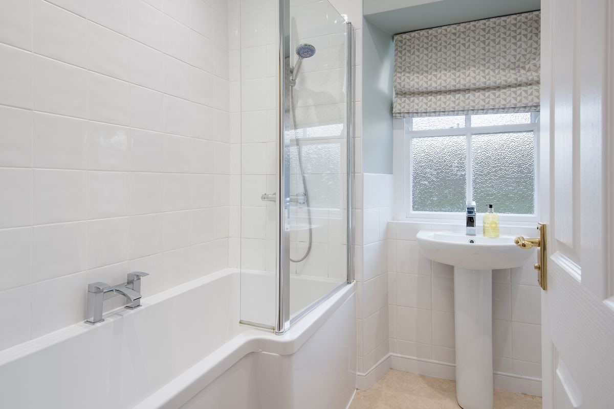 Curlew Cottage - family bathroom with bath and shower over, WC and basin