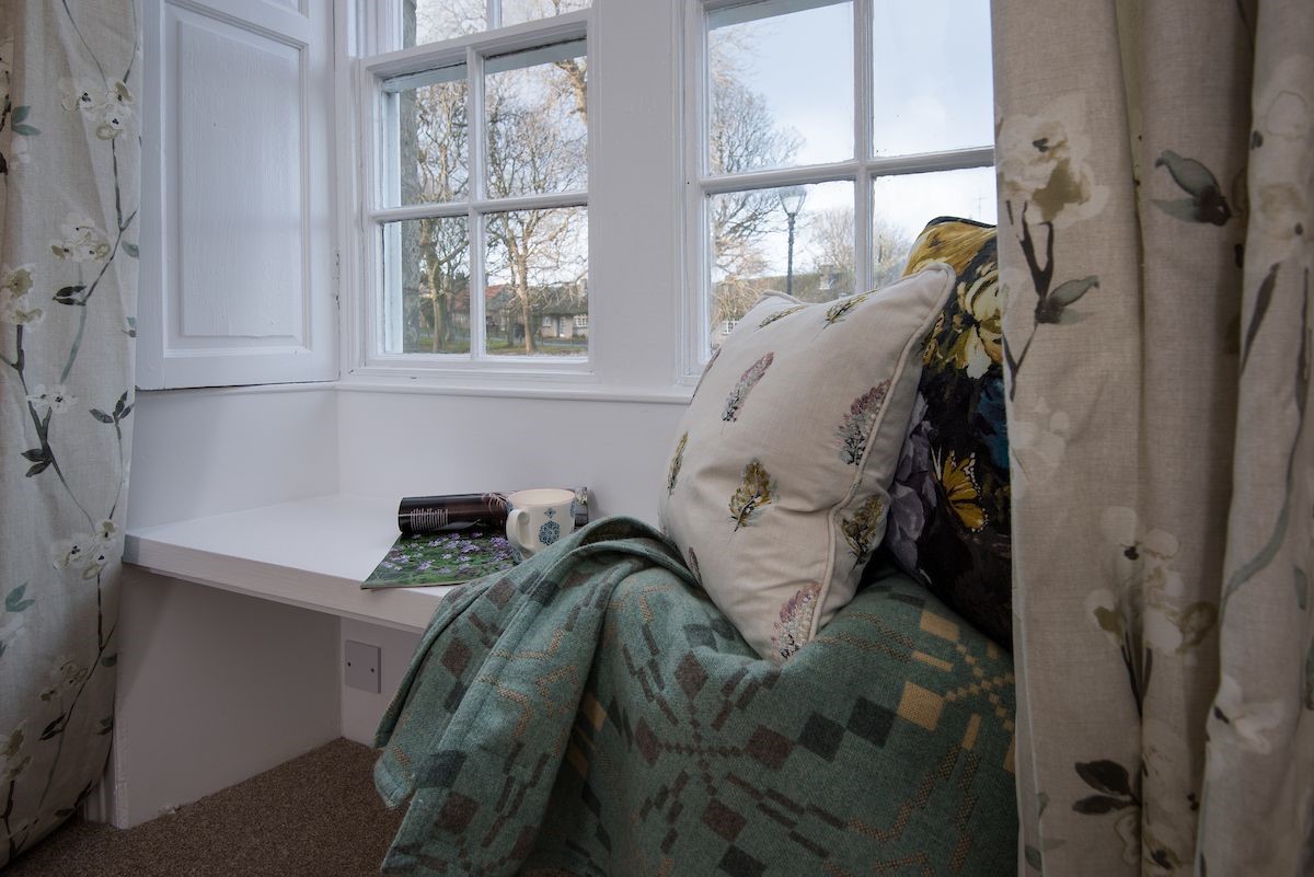 Curlew Cottage - window seat in bedroom one looking out onto Bamburgh village
