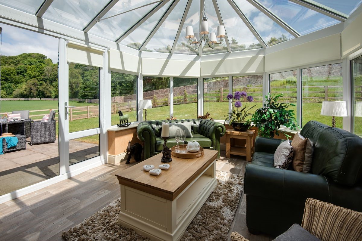 Dryburgh Stirling Two - conservatory with sofas, coffee table and doors leading into the garden