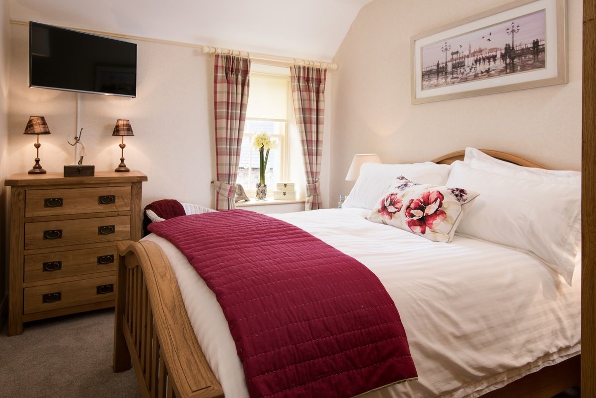 Dryburgh Stirling Two - bedroom one on the first floor with double bed, chest of drawers and TV