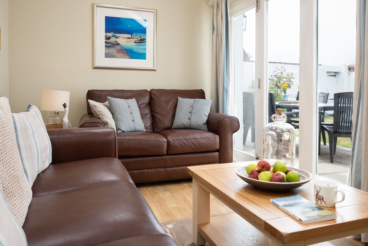 Crosslea - snug with sofas and doors leading into the garden