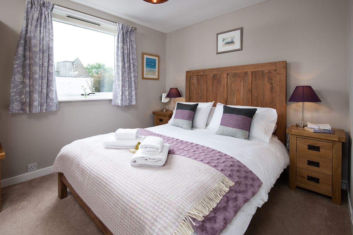 Crosslea - bedroom one on the mid floor with double bed and side tables