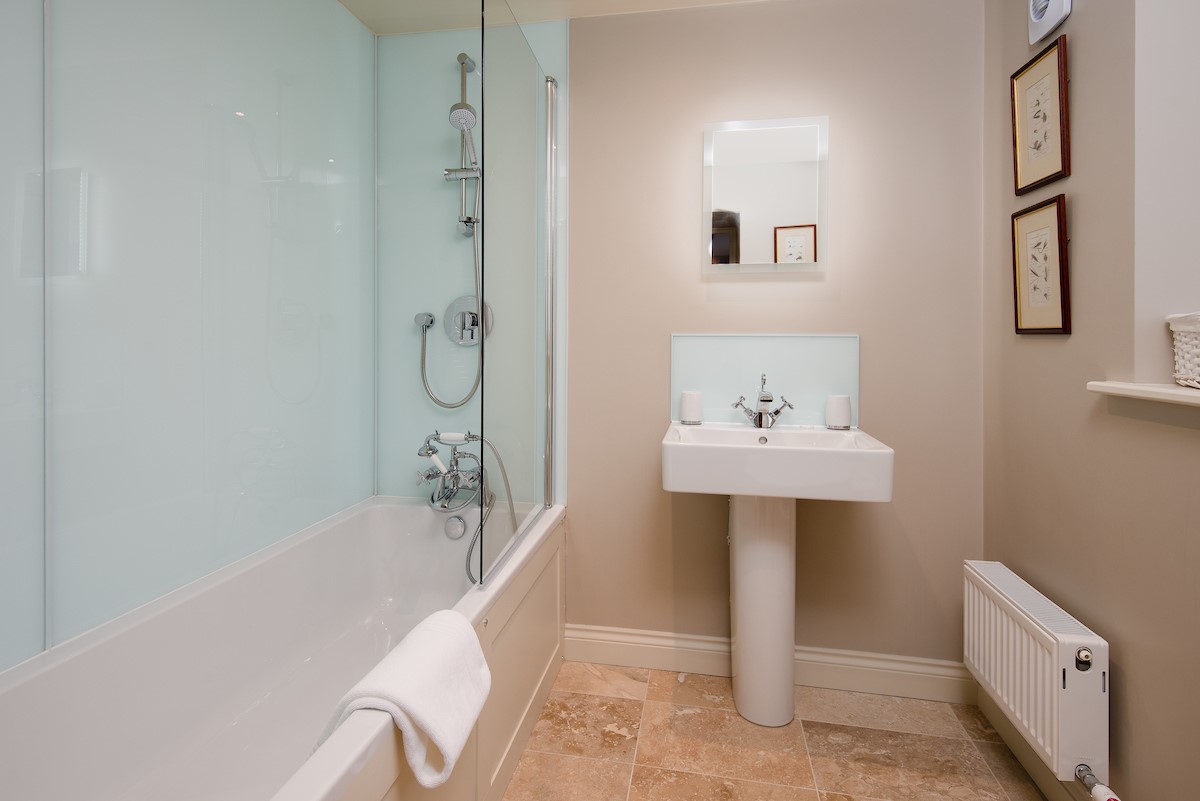 Countess Park - bedroom three en-suite bathroom with bath and shower over, WC and basin
