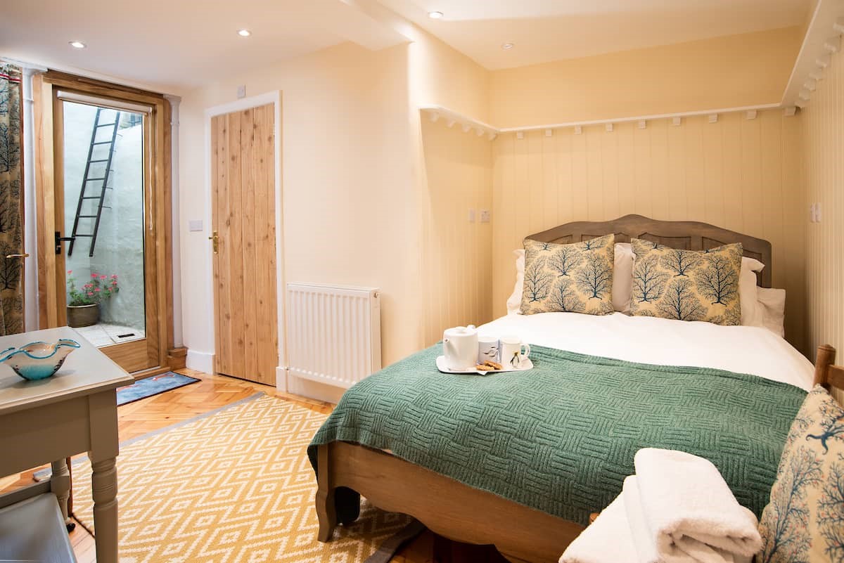 The Craftsman's Cottage - bedroom one on the ground floor with double bed and access to courtyard
