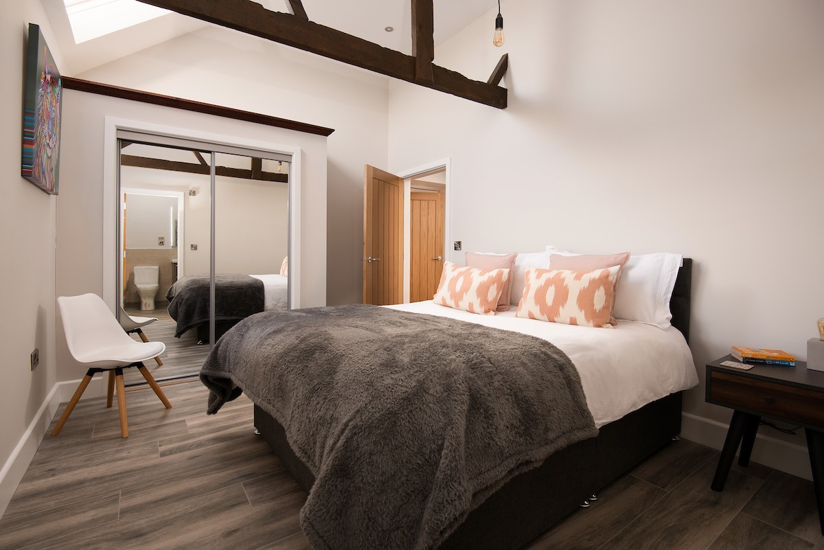 The Steading at West Lyham - bedroom four with king size bed, side tables and double wardrobe