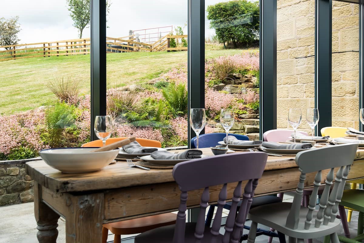 Poppy House - dining area with feature windows overlooking the garden
