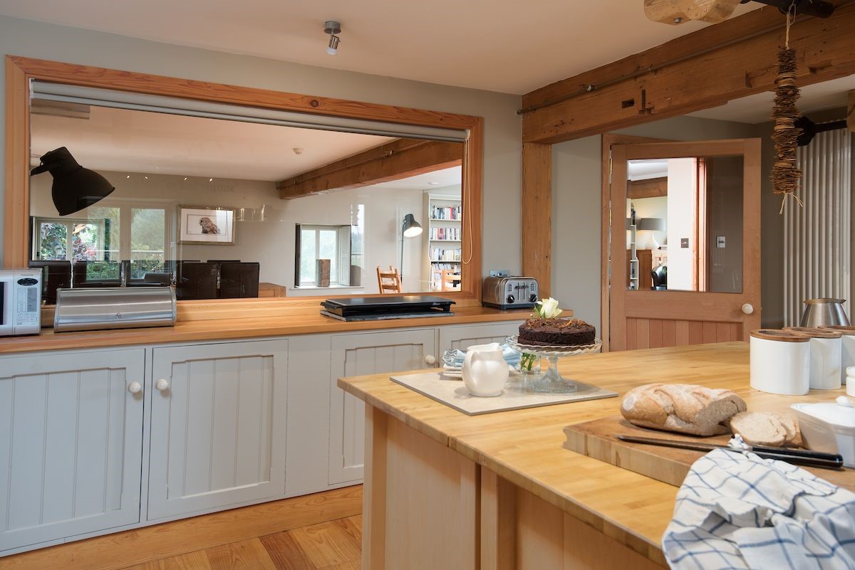 Heiton Mill House - kitchen with window looking through to open plan living area