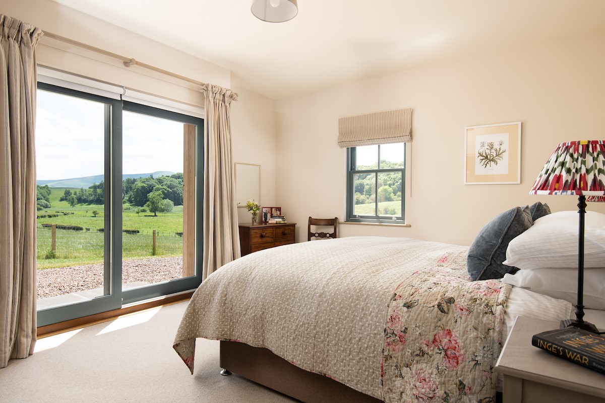 Housedon Haugh - bedroom two with sliding doors leading to the garden