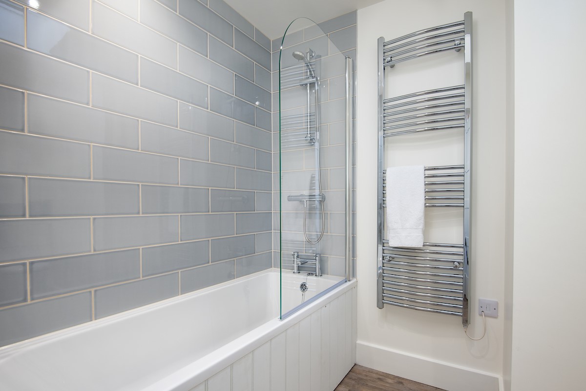 Wild Chive Lodge - the family bathroom benefits from a bath with overhead shower and large heated towel rail