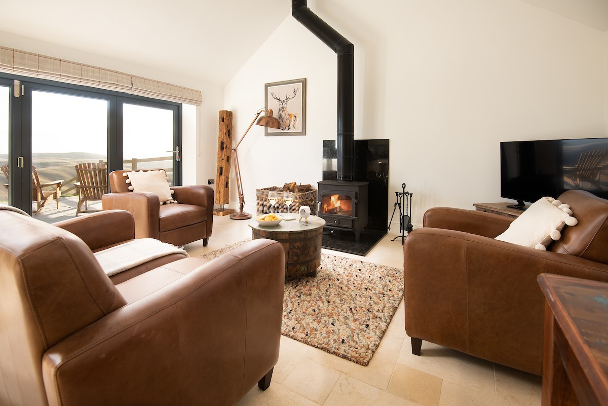 The Hemmel - cosy up on the sofa by the wood burning stove - please note, furniture has been updated. New photographs pending - 1 fabric sofa and 1 leather armchair now provided.