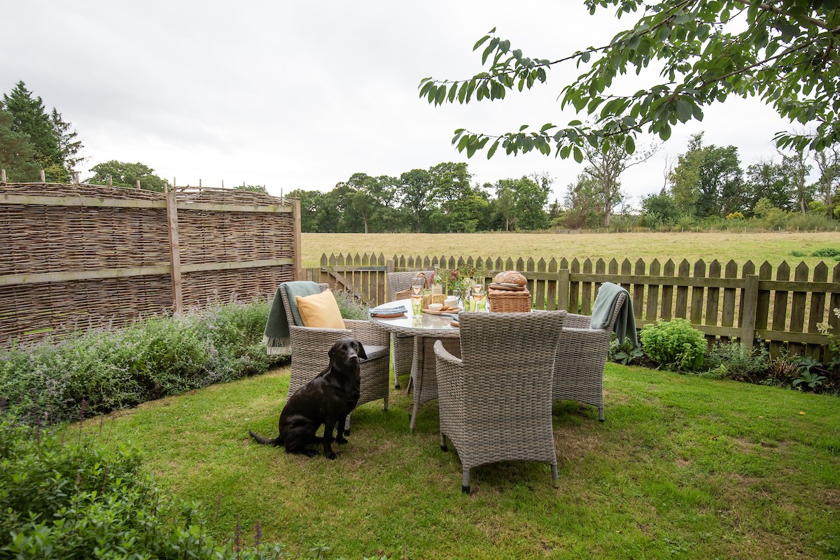 Cuthbert House - outdoor dining area with views across the field at the rear of the property