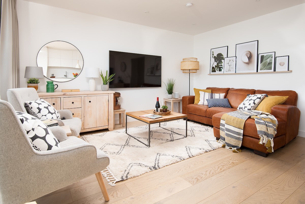 6 The Bay, Coldingham - the botanical prints and a tan leather chaise sofa make for a relaxed Scandi-chic open-plan living space