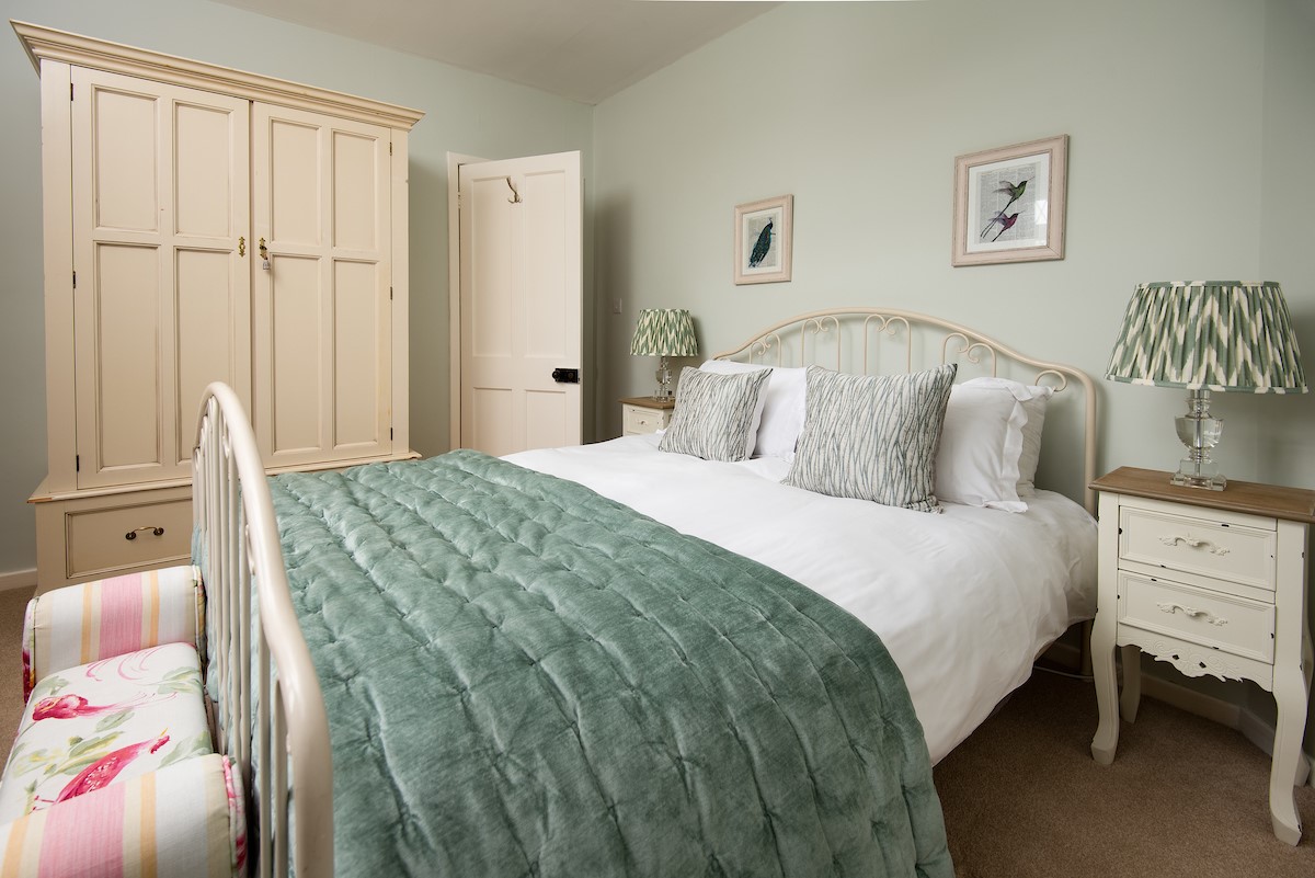 Kilham Cottage - bedroom one with king size bed, wardrobe with drawer below, bedside tables and lamps