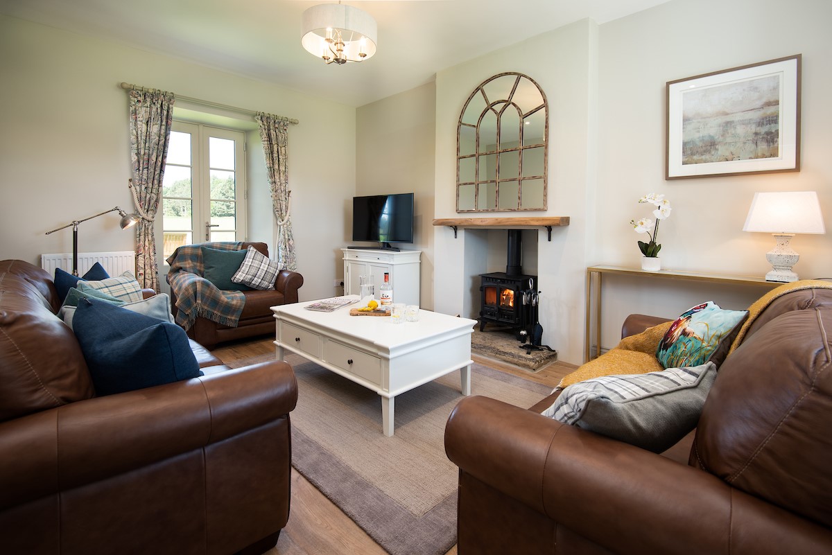 Overview Cottage - living room with large sofas and multi-fuel stove