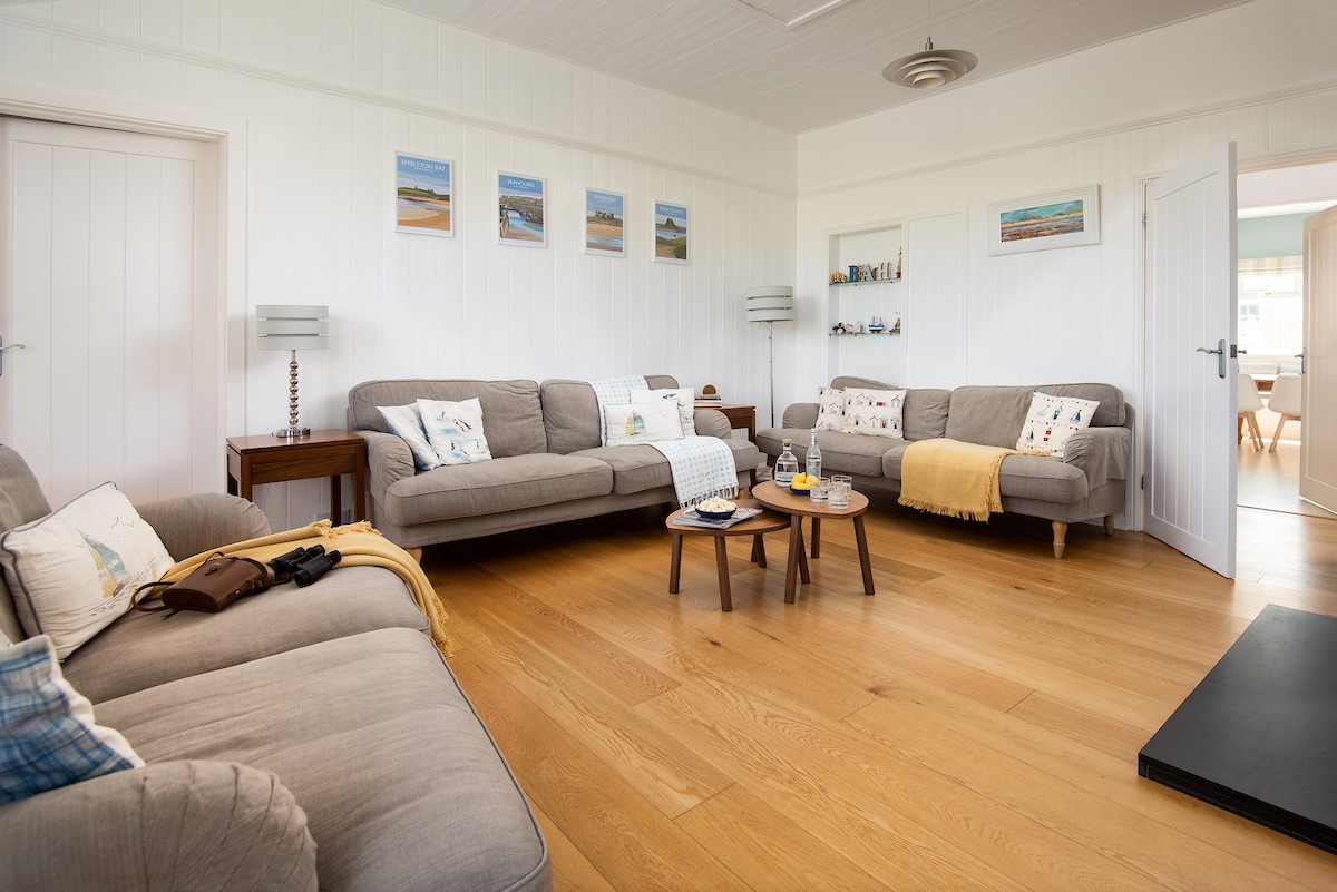 Driftwood Bamburgh - sitting room with two large sofas and one double sofa for guests to relax on