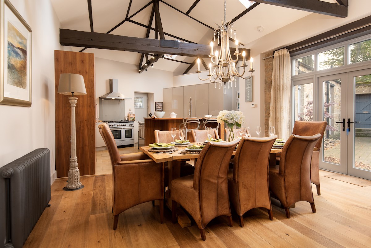 Coach House - open-plan kitchen and dining area with French doors leading to the courtyard
