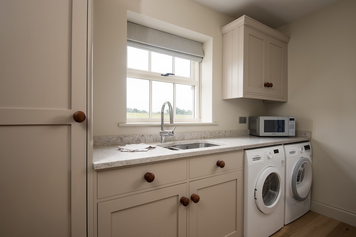 Risingham Cottage - utility room with washing machine and tumble dryer