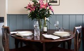 Glenburnie - dining table with seating for two guests and fresh lilies