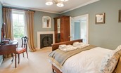 Abbey House - bedroom two with antique double bed, dressing table and fireplace