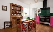 Walltown Farm Cottage - kitchen dining table with 4 chairs and vintage sideboard and dresser beyond
