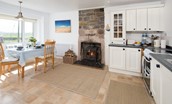 Beachcomber Cottage - kitchen with dining table and wood burning stove