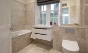 Chaffinch Cottage - tiled family bathroom with bath and shower over, WC and basin