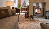 Coach House - the sitting room with wood burning stove leading through into the dining and kitchen area