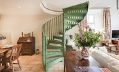 East Cottage - statement green spiral staircase from the open-plan living area up to the first floor