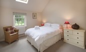 Gardener's Cottage - bedroom two with double bed, side table, chair and chest of drawers
