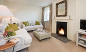 Garden Cottage - sitting room with two sofas, open fire and TV