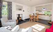 Garden Cottage - open-plan living area and kitchen with wood burning stove and dining space for four guests