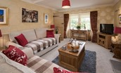 Dryburgh Stirling One - sitting room with sofas, TV, wood burning stove and coffee table