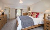 Dryburgh Stirling One - bedroom one with double bed, side tables, chest of drawers, walk-in wardrobe and en suite bathroom