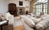 Beeswing - sitting room with inglenook fireplace with electric stove and large arched window  - please note this was originally a wood burner as pictured, but this has now been changed to an electric stove for ease of use