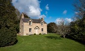 Garden House - front view of the house sitting on the banks of the River Tweed surrounded by mature trees