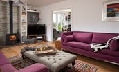 Moo House - cosy sitting room with log burner, sofas, arm chairs and Smart TV