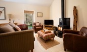 Leyland Barn - cozy open plan sitting room area with sofa, two armchairs and wood burning stove