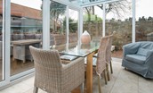 Friars Farm Cottage - glass dining table with 6 chairs where guests can enjoy meals with views of the garden